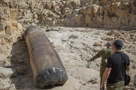 Israeli military personnel inspect the apparent remains of a ballistic missile lying in the desert near the city of Arad, following a massive missile and drone attack on Israel by Iran on April 13. (Photo by Ilia Yefimovich/picture alliance via Getty Images)