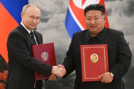 Russian President Vladimir Putin (L) and North Korean leader Kim Jong Un shake hands after signing a mutual defense treaty in Pyongyang on June 19. (Photo by Kristina Kormilitsyna / POOL / AFP via Getty Images, distributed by Sputnik, the Russian state agency)