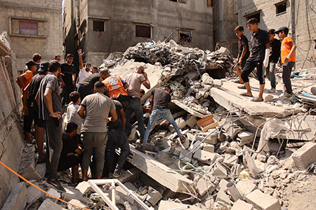 Palestinians search for survivors amid the rubble of a building that collapsed after an Israeli bombardment struck an adjacent structure on Sept. 23 in Gaza City. (Photo by Omar Al-Qattaa/AFP via Getty Images)