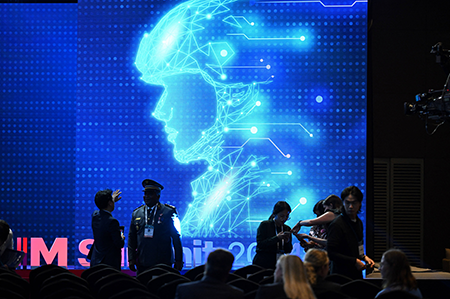 Participants chat in front of an electronic image of a soldier at the Responsible AI in the Military Domain (REAIM) summit in Seoul in September. The summit, as with most multilateral discussions on AI, focused on the risks of military AI but the technology can also be used to mitigate the proliferation of weapons of mass destruction, authors Yanliang Pan and Daihan Cheng write. (Photo by Jung Yeon-Je/AFP via Getty Images)