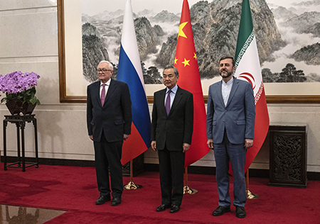 Chinese Foreign Minister Wang Yi (C) welcomes Russian Deputy Foreign Minister Sergey Ryabkov (L) and Iranian Deputy Foreign Minister Kazeem Gharibabadi before a meeting in Beijing March 14 regarding the Iranian nuclear issue. (Photo by POOL/AFP via Getty Images)