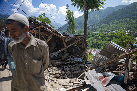 A man walks past a shop May 15 that was damaged in cross-border shelling in Uri, a town near the Line of Control, the de facto border in Kashmir. A week earlier, India and Pakistan exchanged missiles, drones, and artillery fire for four days following a deadly attack on tourists on the Indian side of Kashmir, which India blamed on Pakistan. (Photo by Idrees Abbas/SOPA Images/LightRocket via Getty Images)