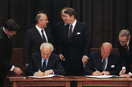 Concluding their 1985 summit in Geneva, Soviet leader Mikhail Gorbachev (L) and U.S. President Ronald Reagan converse while Soviet Foreign Minister Eduard Schevardnadze (L) and U.S. Secretary of State George Schultz sign documents. (Photo by Bettman Archives via Getty Images)