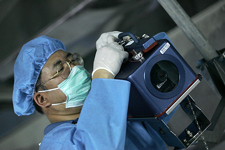An unidentified inspector of the International Atomic Energy Agency (IAEA) installs a camera at Iran’s Isfahan Uranium Conversion Facilities, south of Tehran, in 2005. The camera is one of the devices that the IAEA uses to keep track of Iran's nuclear activities.  (Photo by Behrouz Mehri/AFP via Getty Images)