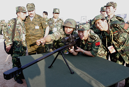 Chinese military officers try out a Russian-made rifle at the conclusion of the two countries' first joint military exercise  August 25, 2005 in eastern China's Shandong Province. More than 7,000 Chinese troops and 1,800 Russian troops took part in the exercise which included a mock invasion by paratroopers on China's east coast. (Photo by China Photos/Getty Images)