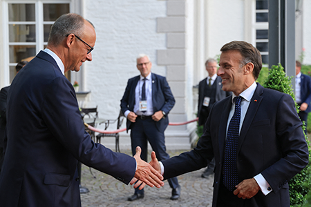 German Chancellor Friedrich Merz (L) greets French President Emmanuel Macron as he arrives at the Grandhotel Schloss Bensberg in Bergisch Gladbach, Germany, July 16, on the eve of the French-German cabinet meeting. The next day, Merz announced that the German military will participate in a French nuclear exercise for the first time. (Photo by Ludovic Marin / AFP via Getty Images)