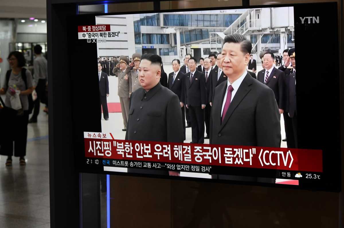 People watch a television news screen showing North Korean leader Kim Jong Un welcoming Chinese President Xi Jinping at Pyongyang airport on June 20, 2019. (Photo by Jung Yeon-je /AFP/Getty Images)