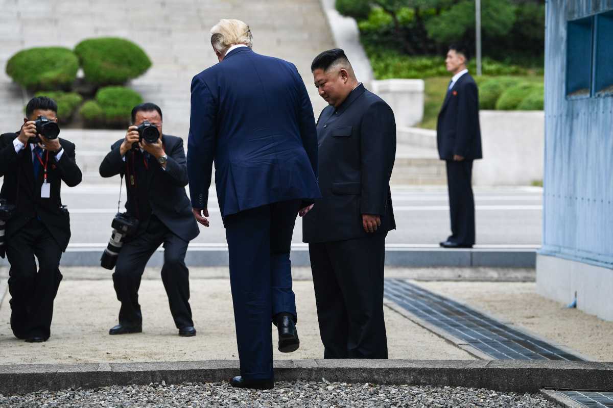 U.S. President Donald Trump steps into the northern side of the Military Demarcation Line that divides North and South Korea, as North Korea's leader Kim Jong Un looks on, June 30, 2019. (Photo by Brendan Smialowski /AFP/Getty Images)